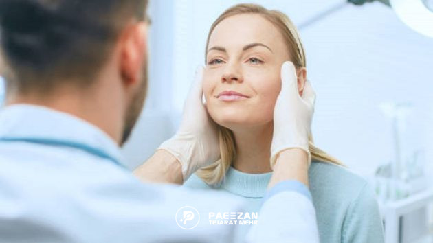 پزشک مرد در حال معاینه پوست صورت زن