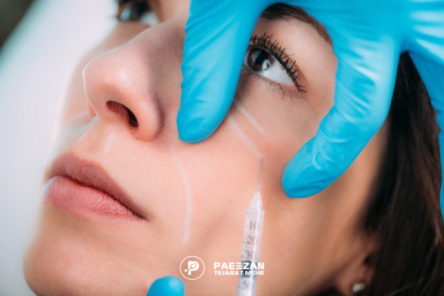 صورت دختری که پزشک یک دستش را روی گونه او گذاشته و با دست دیگر روی گونه او پروفایلو تزریق می کند