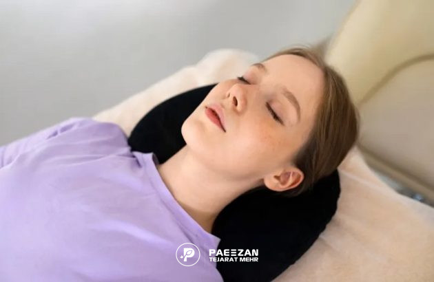 دختری که چشم های خود را بسته و روی تخت کلینیک زیبایی دراز کشیده است