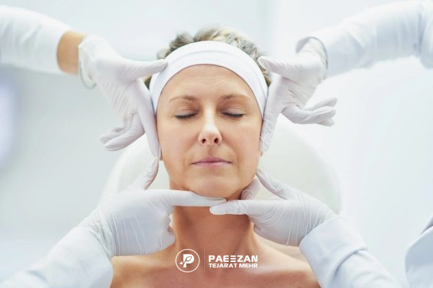 صورت یک زن میانسال که دو نفر چهار دست خود را در اطراف صورت او گرفته اند