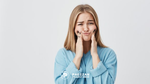 دختری که دو دست خود را روی صورتش فشار داده است