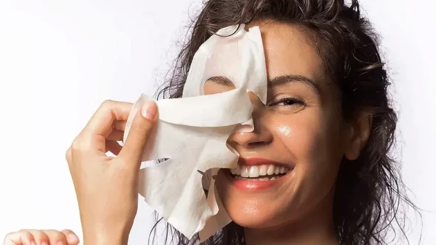 دختری که ماسک صورت را از روی پوست خود برمی دارد