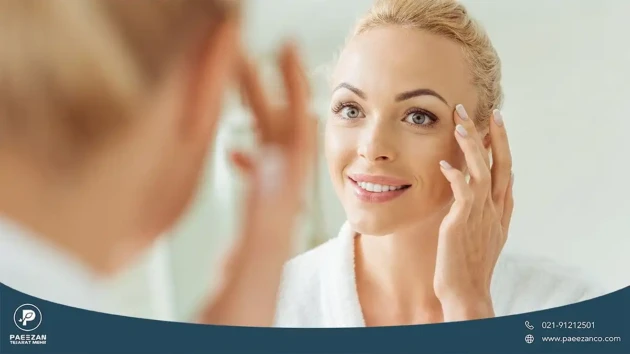 دختری که صورت خود را در آینه می بیند و دست خود را روی صورتش گرفته است
