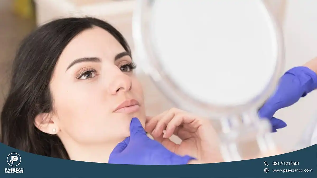 راهنمای جوانسازی پوست در طب سنتی 1 دکتری که دست خود را روی چانه دختر گرفته و پوست صورت او را معاینه می کند