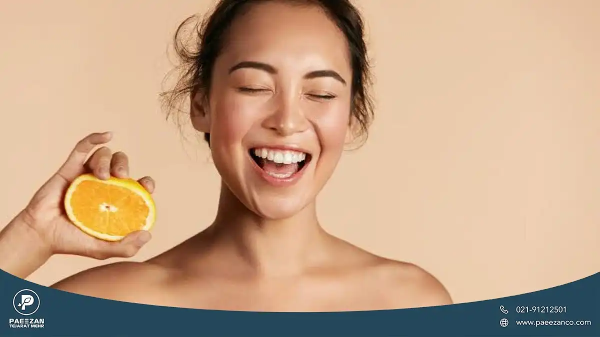 برای جوانسازی پوست صورت چه بخوریم؟ 4 دختری که در دست راستش یک نصفه پرتغال نگه داشته و لبخند زده است