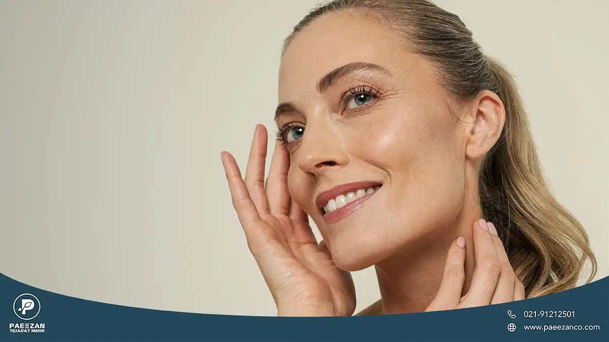 انواع روش های از بین بردن خطوط پنجه کلاغی 1 دختری که لبخند می زند و یک دست را کنار چشمش گرفته و دست دیگر را روی گردنش