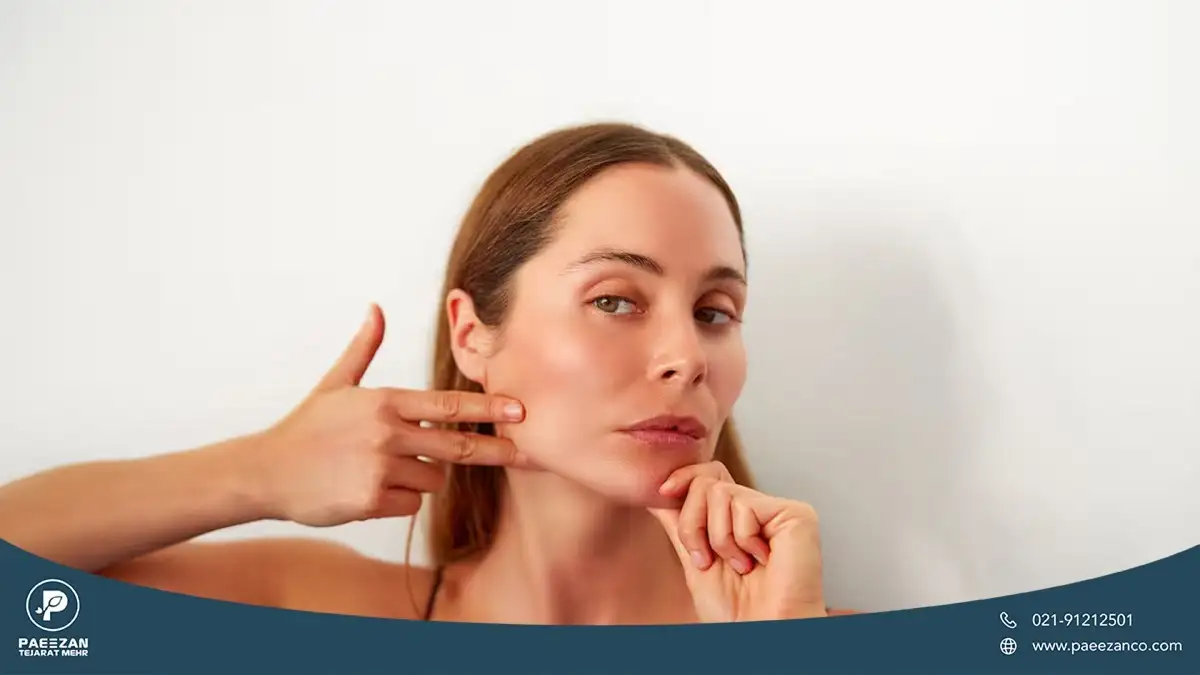 دختری که صورت خود را به یک طرف مایل کرده و با دست پوست خود را ماساژ می دهد