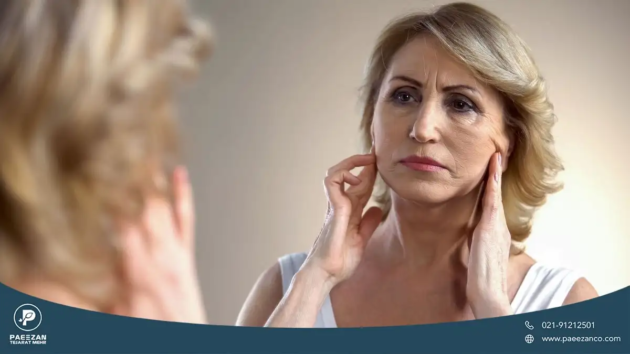 دختری که روی پوستش چروک دارد و پوست خود را در آینه نگاه می کند
