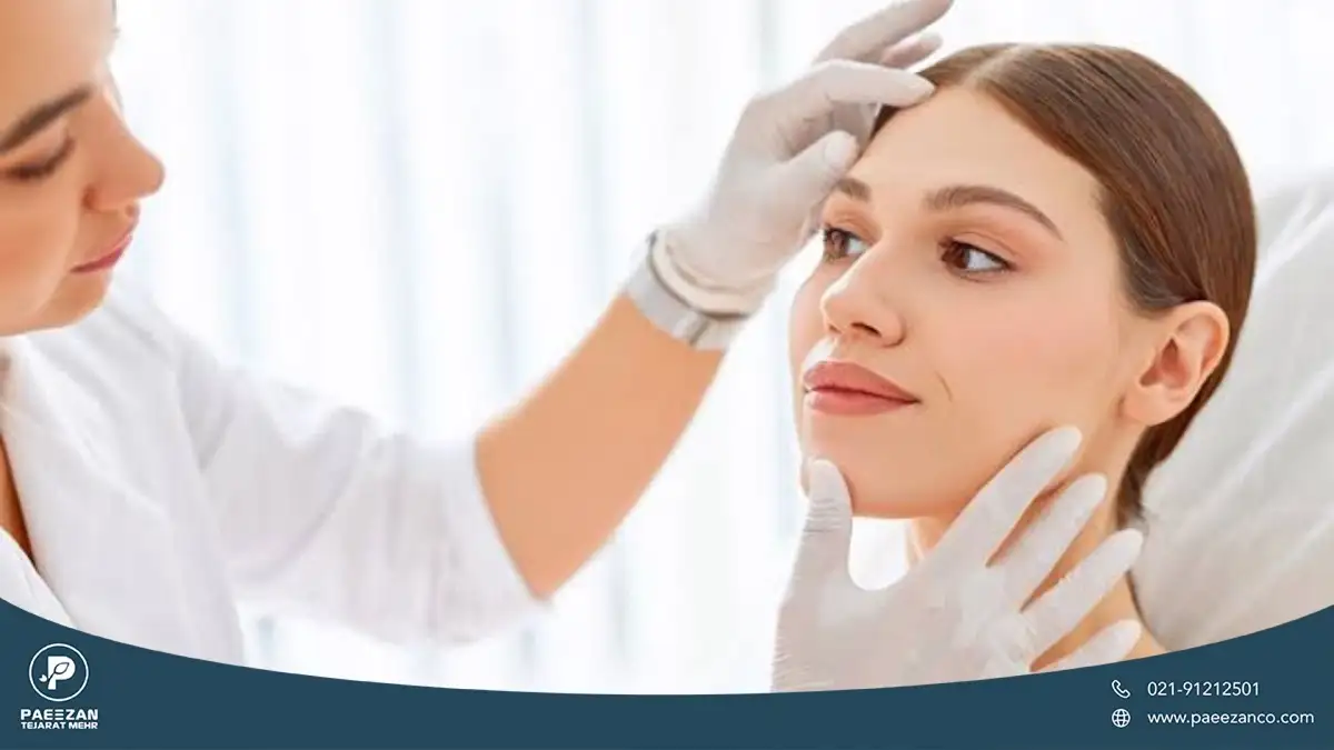 دختری که لبخند زده و پزشک صورت او را معاینه می کند