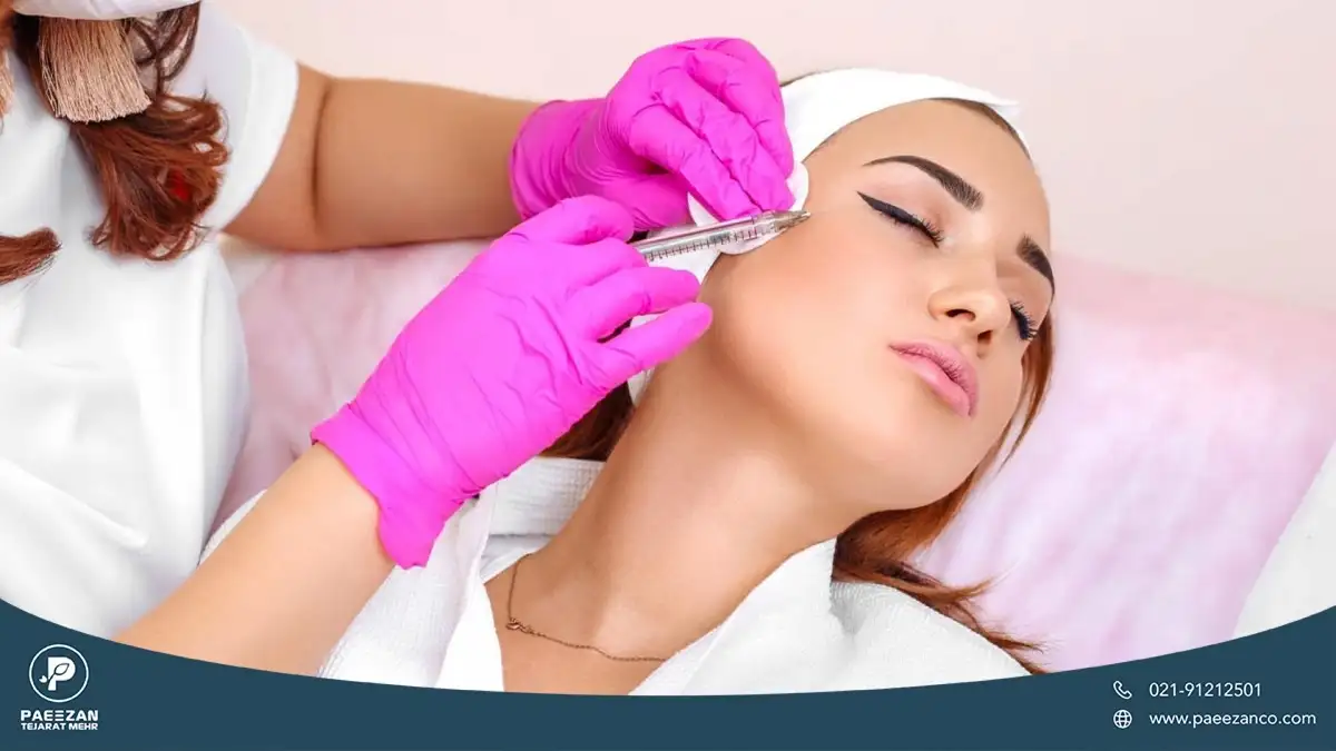 دختری که صورت خود را به سمت چپ متمایل کرده و پزشک به گونه او مزوژل تزریق می کند